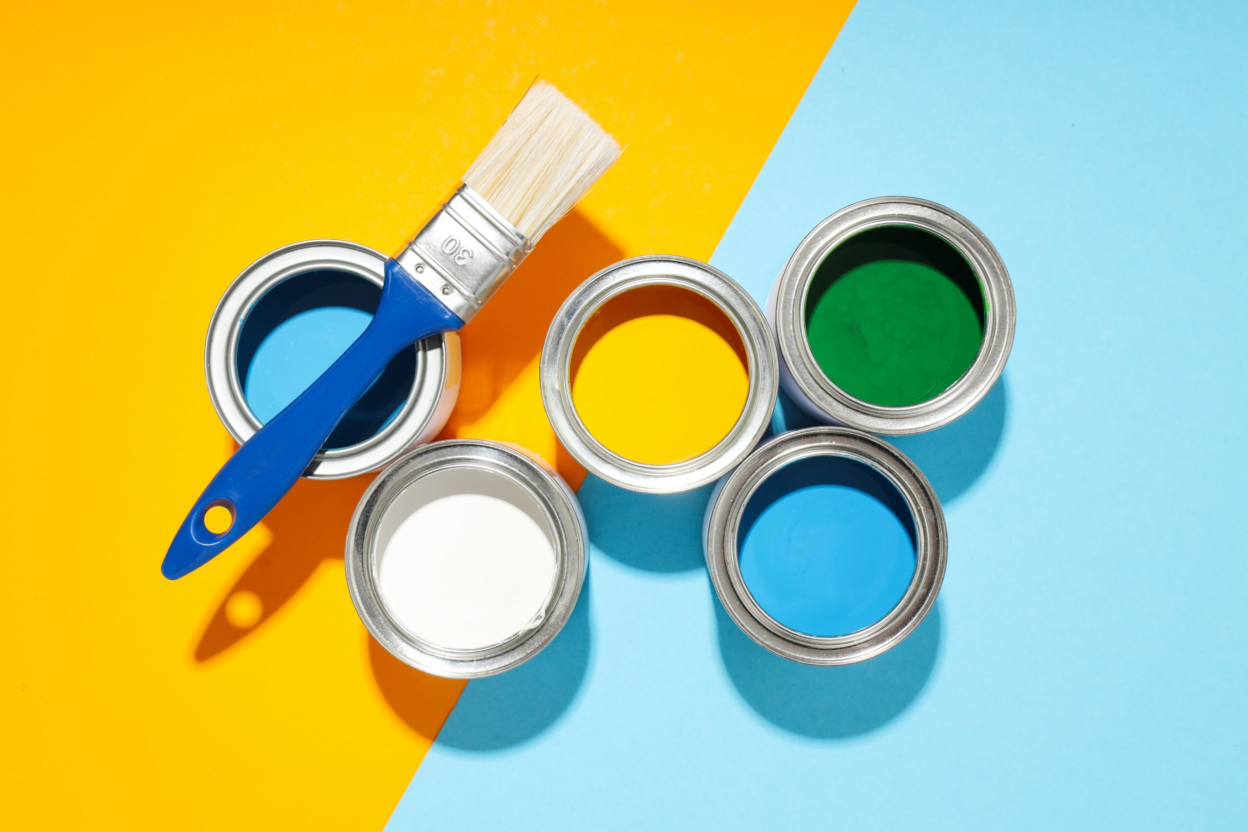 pots de peinture colorés sur fond jaune et bleu 